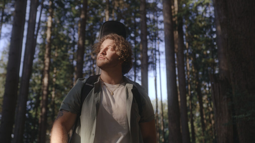 Me, Myself & Misery standing in a forest, looking upward
